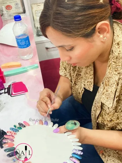 A student works on her color wheel, practicing different nail art techniques and color combinations.