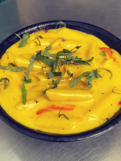 A close-up of the creamy white sauce pasta from my Pasta & Pasta dish, garnished with fresh basil.