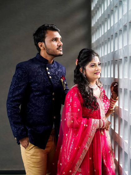 Another look at this stunning couple. The groom's navy Jodhpuri suit and the bride's bright pink lehenga create a beautiful contrast that is perfect for wedding photos.