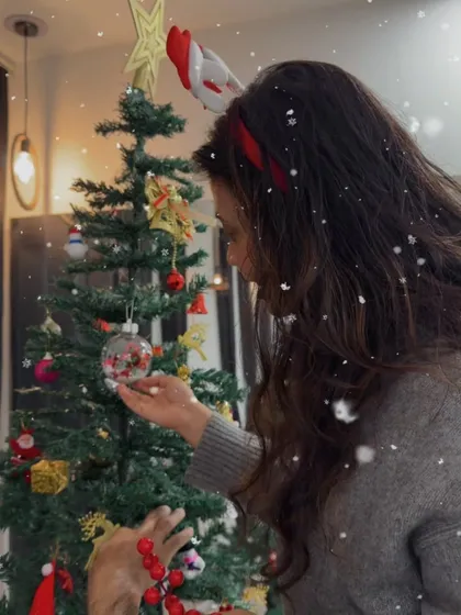A snowy effect adds a little magic to this photo of me decorating the tree. It really feels like the most wonderful time of the year.