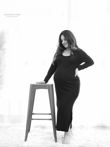 A simple and elegant black and white portrait. The high-key lighting and minimalist setting put all the focus on the mother-to-be and her beautiful silhouette.