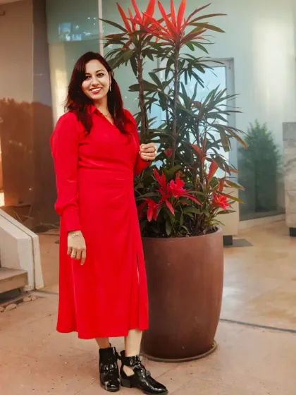 Posing confidently in a vibrant red dress. As an emcee, your presence sets the tone, and I always aim to set a tone of vibrant energy.