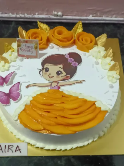 A fun and creative cake for the mango season, featuring a girl in a dress made of fresh mango slices.