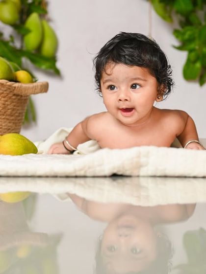 A happy baby enjoying a seasonal mango-themed photoshoot.