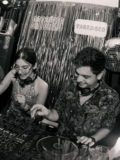 A black and white shot of me and a fellow DJ sharing a laugh behind the decks. Collaboration is key to my events, and I love sharing the console with artists I admire.