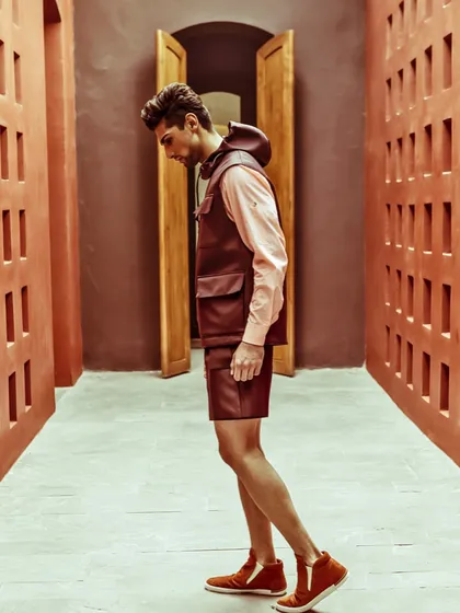 An editorial look for 'The Man' magazine, featuring a layered Dior ensemble. I styled this leather utility vest over a long-sleeved shirt with matching shorts, creating a look that is both utilitarian and high-fashion against a strong architectural backdrop.