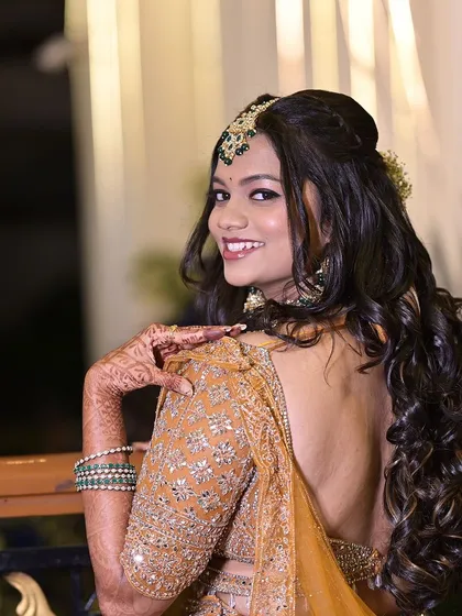 A back view of the bride's reception hairstyle, featuring beautiful loose curls and a delicate hair accessory.