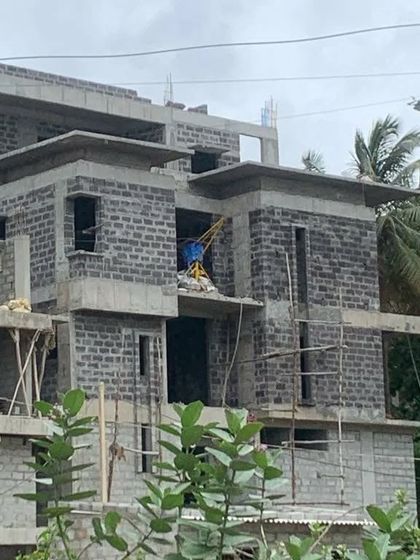 Another angle of the villa under construction, showing the complex, multi-level structure and cantilevered roofs before the final finishes are applied.