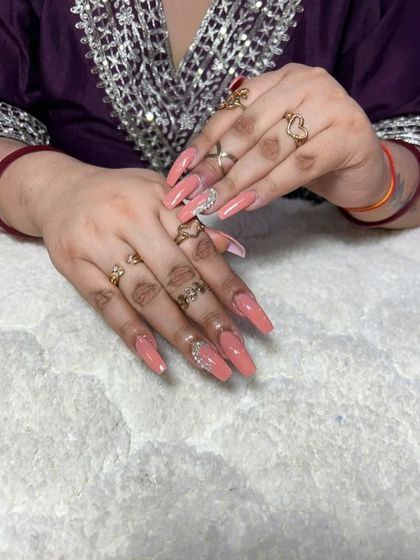 A beautiful set of long, square extensions in a solid peachy-nude, with a delicate rhinestone accent.