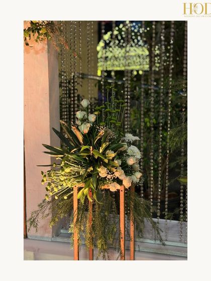 A beautiful floral arrangement on a modern gold stand, a simple yet artistic detail that can elevate any corner of the venue.