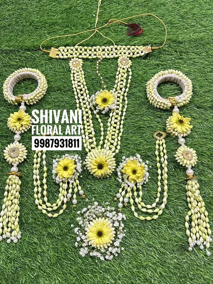 A beautiful bridal jewellery set for Haldi, featuring yellow flowers and Tagar buds. The set includes a choker, a long necklace, and heavy kalire.