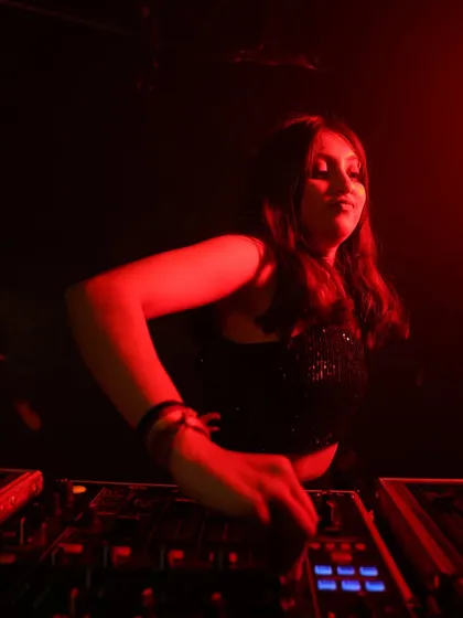 A close-up shot under intense red lighting. I'm focused on the mix, feeling the bass and preparing for the next drop.