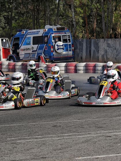 A race in progress with the medical support ambulance visible in the background, highlighting our commitment to driver safety.