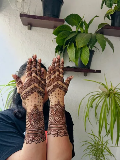 A lovely design featuring a mix of bold mandalas on the forearms and delicate dot work on the palms, creating a striking contrast in this party mehndi.