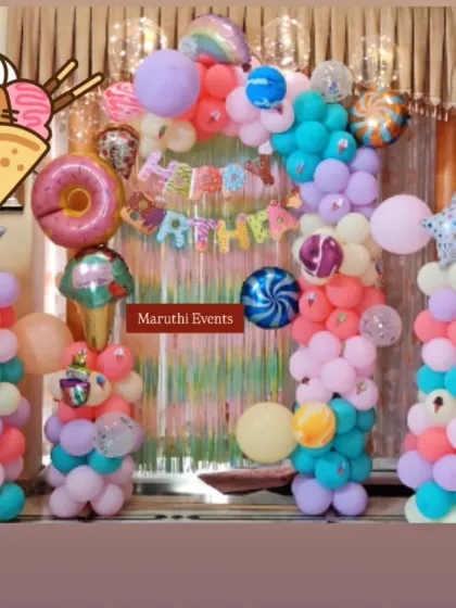 Another version of the Candyland theme, with a pastel foil curtain and balloon columns decorated with candy and donut foil balloons.
