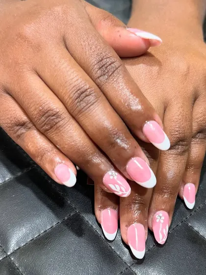 A closer look at the classic French manicure, showing the clean lines and the subtle floral accent with a rhinestone center.
