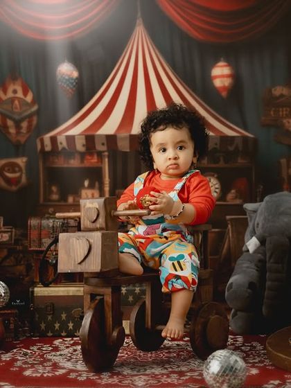 Welcome to the circus. This elaborate setup features a toddler as the star of the show, surrounded by classic circus props and a vintage aesthetic.