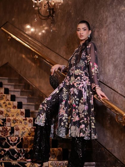 A full-length shot from the India Couture Week project, showing how the sleek hairstyle complements the elaborate outfit.