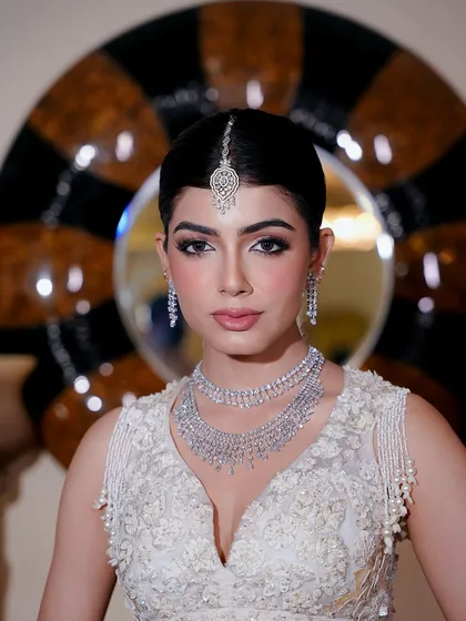 A striking portrait of the bride against a modern backdrop. Her soft glam makeup, with defined eyes and a neutral lip, looks powerful and elegant.