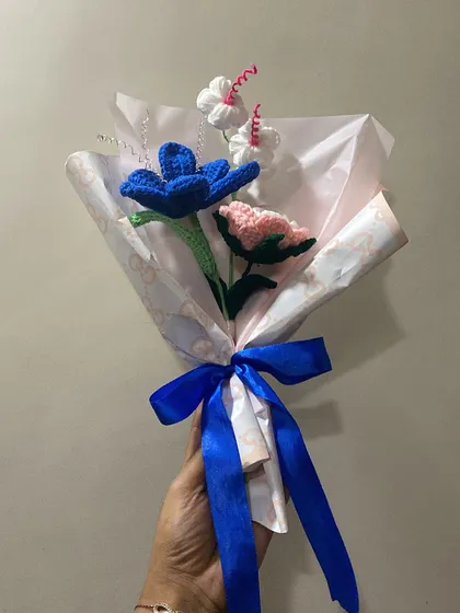A bouquet that lasts a lifetime. This arrangement of blue, pink, and white flowers is a sweet and timeless gift, wrapped with a simple blue ribbon.