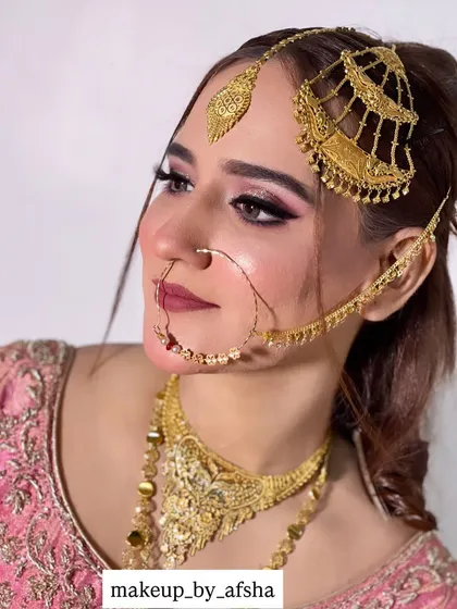 A detailed side profile showcasing how I set the passa, maang tikka, and nath. Getting the jewellery placement just right is crucial for a comfortable and flawless bridal look. The pink-toned eyeshadow adds a touch of softness to the bold gold jewellery.