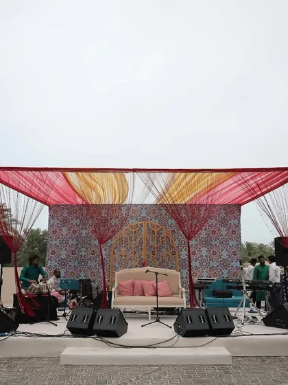 The outdoor stage for a musical evening in Bahrain, with a backdrop of intricate Moroccan patterns, ready for a night of entertainment under the stars.