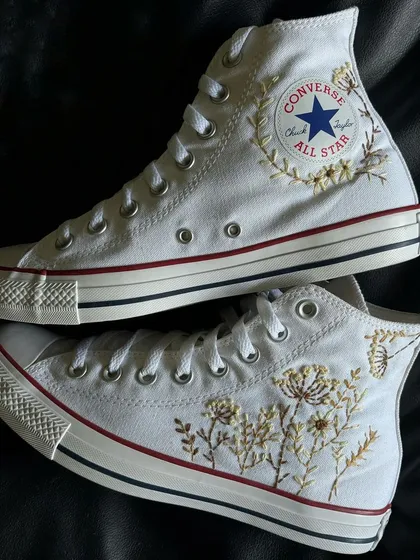 The full pair of custom embroidered Converse, showing the different floral patterns.