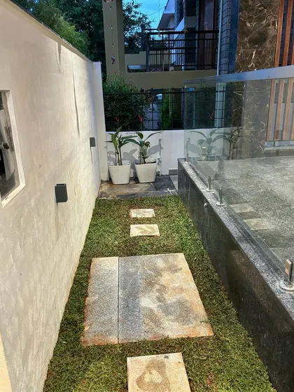 A narrow side yard transformed with a simple lawn and stone pavers. This practical and elegant solution creates a functional walkway while still incorporating a touch of green.