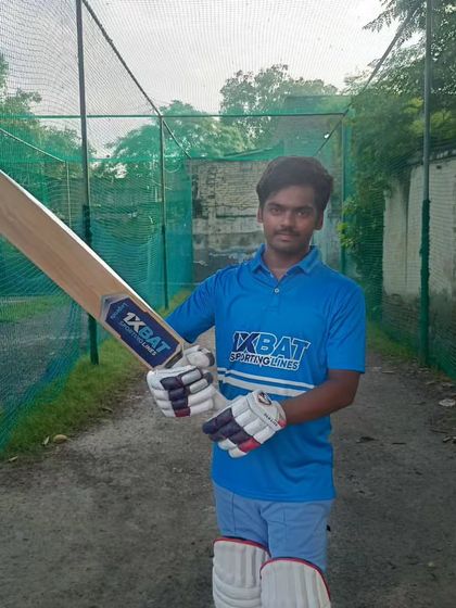 A young batsman proudly displaying his cricket bat from our partners. Quality equipment is a key part of our training setup.
