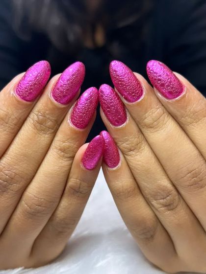 A vibrant, textured magenta glitter polish for a full-on sparkle effect.