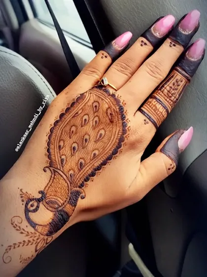 A simple yet striking design featuring a single, bold peacock motif on the back of the hand.