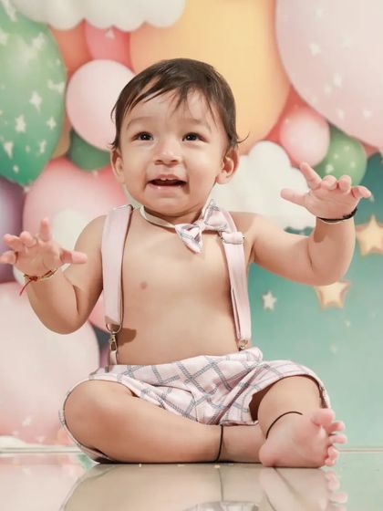 Look at those happy hands! This little one is ready to dig into his first birthday cake. The excitement is real!
