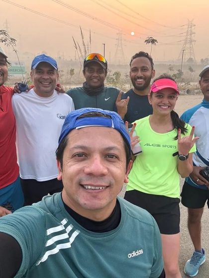 Our running group posing for a selfie against the sunrise during a long training run. These early morning miles are where bonds are forged.