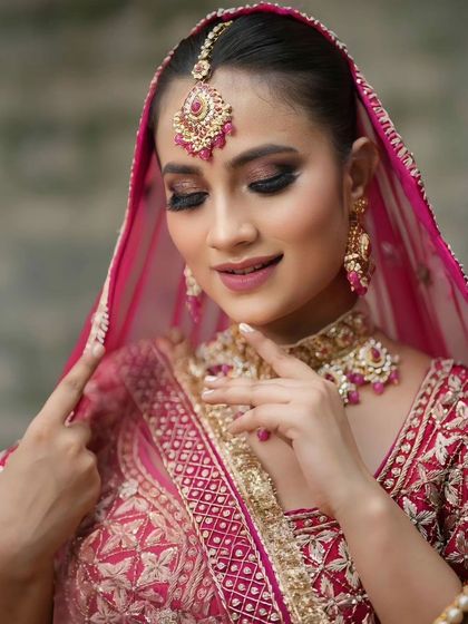 A serene portrait of the bride adjusting her dupatta. The makeup is soft and romantic.