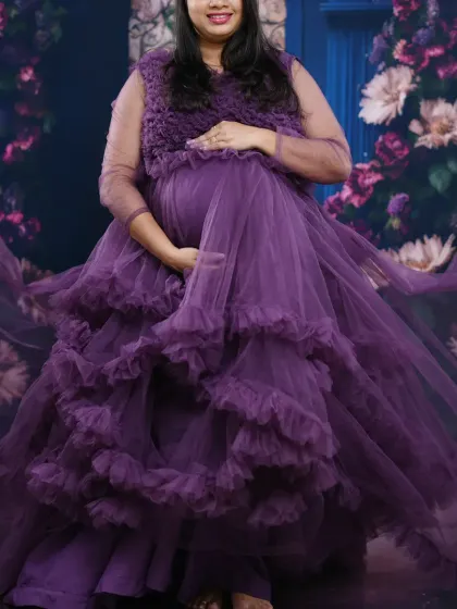 This mauve gown is a gorgeous English color that photographs beautifully. The flowing fabric and ruffle details create a dramatic and elegant silhouette for maternity shoots.