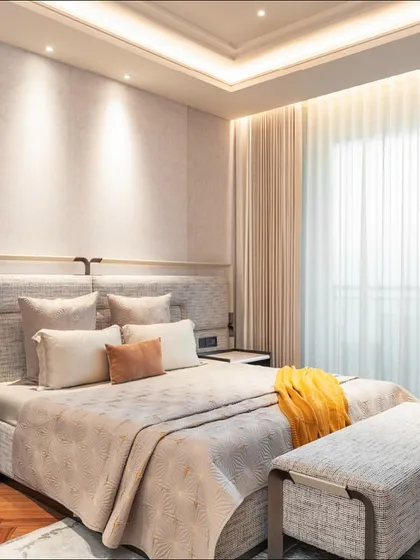 A bedroom should be a personal retreat, a space of quiet rest. For this master bedroom, we designed a custom upholstered headboard with integrated metal detailing, paired with bespoke nightstands. The interplay of soft textiles, warm lighting, and clean lines creates an atmosphere of serene, understated luxury.