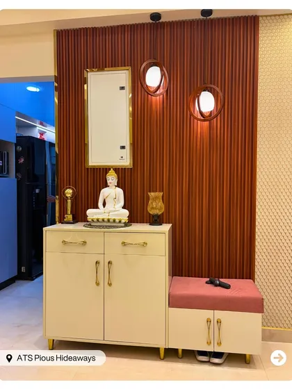 This foyer area includes a beautiful console table with a Buddha statue, creating a serene and welcoming mandir space right at the entrance of the home.