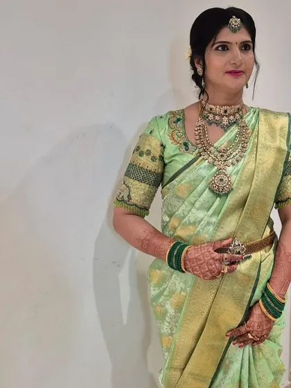 Vedha's poise and the intricate embroidery on her blouse showcase her impeccable style.