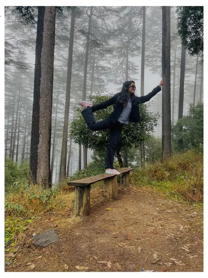 Practicing Natarajasana on a bench in a misty forest. The stillness of the mountains is a perfect backdrop for finding your inner balance and peace.