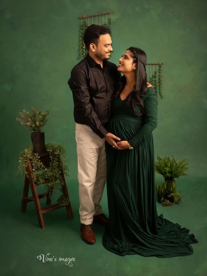 A sweet and classic pose. The couple looks at each other with love, their hands joined over the baby bump, symbolizing their partnership on this journey.