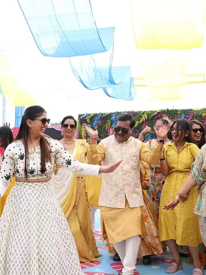 Leading the family in a dance. My white and green lehenga stood out beautifully against the yellow theme of the guests' attire.