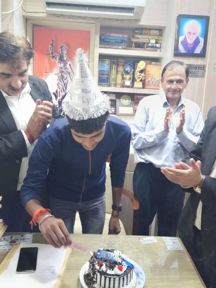 Vimal cutting his birthday cake, surrounded by senior and junior advocates who support his journey.