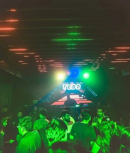 Another angle of the club, with green laser lights cutting through the darkness.