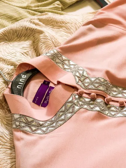 A beautiful pink kurta with delicate mirror work along the neckline. This piece is perfect for a daytime event, offering a soft and celebratory pop of color.