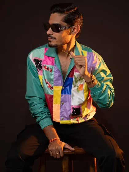 A seated pose that gives a different perspective on the jacket. The styling is perfect for a creative professional or anyone looking to make a fashion statement.