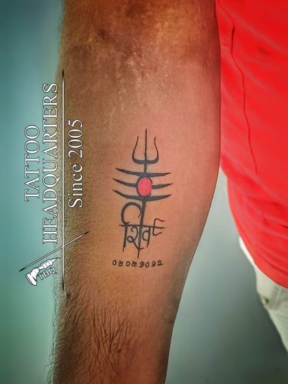 A symbolic tattoo of Shiva's third eye and Trishul, with the name "Shiva" written in a stylized script.