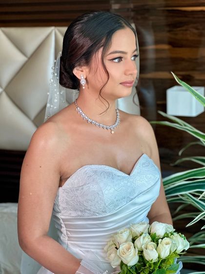 A side profile of Beracah, showcasing her elegant updo and the flawless finish of her makeup. The look was designed to be picture-perfect from every angle.