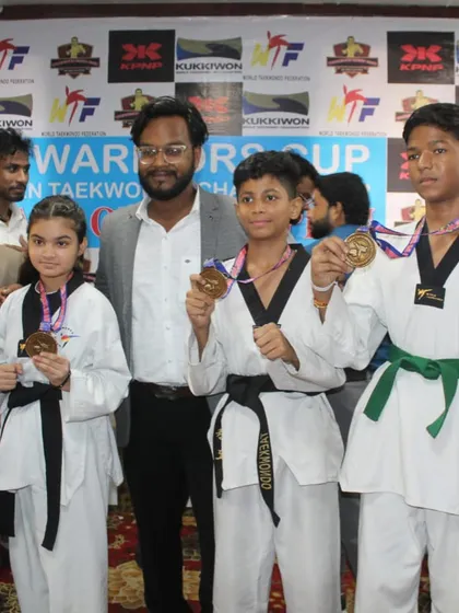 Some of my senior students, including a black belt and green belt, posing with their medals after the competition. They serve as role models for the younger kids in the academy.