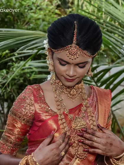 A full view of Swapna's traditional Kerala bridal look, with the classic red and gold saree and heavy temple jewelry.