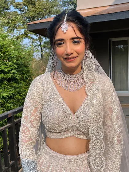 The complete look for this stunning white-themed wedding. The makeup is fresh and radiant, perfect for an outdoor ceremony and designed to last all day.